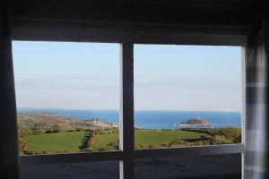 a view of the ocean from a window at Scandi Cabin On A Hill, With Stunning Views Across Cornwall in Nancledra