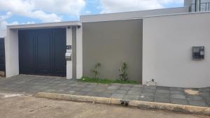 a garage with a blue door on a building at Happy Buritis, eventos e hospedagem in Primavera do Leste