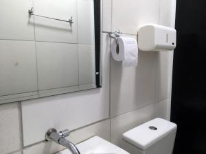 uma casa de banho com um WC, um lavatório e um espelho. em Hotel Music and Sports em São Paulo