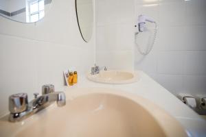 ein Bad mit einem Waschbecken und einem Spiegel in der Unterkunft Hotel Raymi in Cusco
