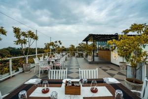 a restaurant with tables and chairs on a balcony at Tripli Hotels Shambhu Villas in Udaipur