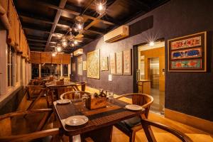 a restaurant with wooden tables and chairs in a room at Tripli Hotels Shambhu Villas in Udaipur