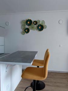 una mesa con una silla y platos en la pared en Studio de charme au Gosier en Le Gosier