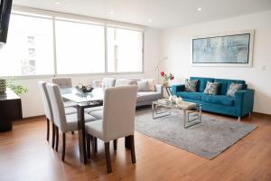 Una sala de estar con un sofá azul y una mesa. en Apartment in Center of Miraflores, en Lima