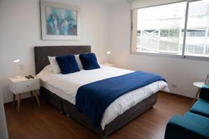 Un dormitorio con una cama grande con almohadas azules. en Apartment in Center of Miraflores, en Lima