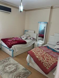 um quarto com 2 camas e um espelho em Tyvally Dom apartment sea view للعائلات فقط em Alexandria