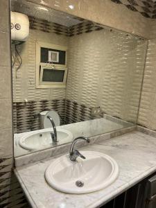 uma casa de banho com um lavatório e um espelho em Tyvally Dom apartment sea view للعائلات فقط em Alexandria