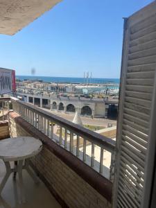 uma varanda com uma mesa e vista para um porto em Tyvally Dom apartment sea view للعائلات فقط em Alexandria