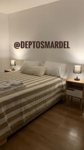 a bedroom with a bed with a sign on the wall at Roca Trust II Semipiso de 3 ambientes para 4 personas en zona güemes con cochera in Mar del Plata