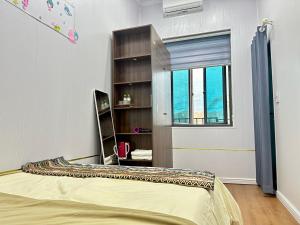 a bedroom with a bed and a book shelf at Cá Homestay-Cao Bằng in Cao Bằng