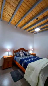 a bedroom with a bed and two night stands with lamps at Sueños Del Pilar II in Godoy Cruz