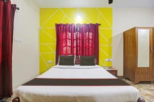 een slaapkamer met een groot bed en een rood raam bij Ferns Guest House in Calangute