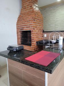 a kitchen with a brick fireplace on a counter at Casa agradável com área gourmet in Ji-Paraná