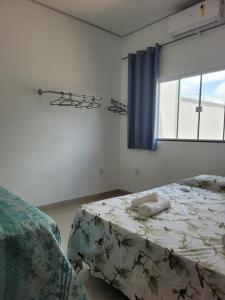 1 dormitorio con cama y ventana en Casa agradável com área gourmet, en Ji-Paraná