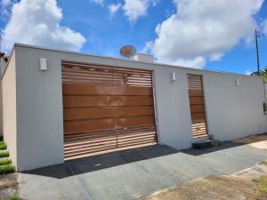 a pair of garage doors on a white building at Casa agradável com área gourmet in Ji-Paraná