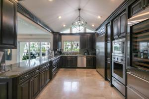 a large kitchen with wooden cabinets and a large island at Paradise Manor in Pompano Beach
