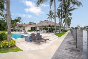 a villa with a swimming pool and palm trees at Paradise Manor in Pompano Beach