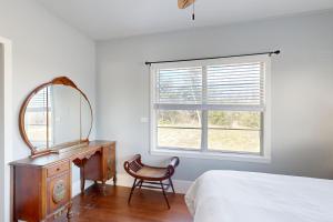 een slaapkamer met een spiegel, een dressoir en een bed bij The Sandpiper in Angleton