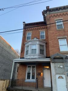 una casa de ladrillo rojo con puerta blanca en The Blue Luxe Apartment West Philadelphia, 10mins Center City, Free Parking en Filadelfia