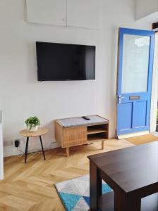 uma sala de estar com uma televisão de ecrã plano na parede em Penlea ~ 1 bedroom Flat with Harbour view em Tarbert