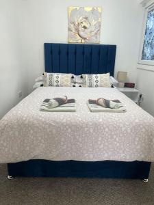 a bedroom with a bed with two slippers on it at Penlea ~ 1 bedroom Flat with Harbour view in Tarbert