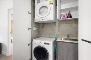 a kitchen with a washing machine and a sink at Sydney Olympic Park Modern 3 Bedroom with Pool & Free Parking in Sydney