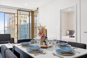 a dining room table with blue dishes on it at Sydney Olympic Park Modern 3 Bedroom with Pool & Free Parking in Sydney