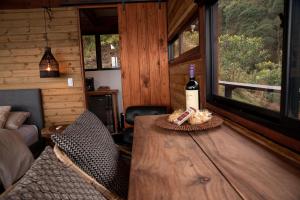 a room with a wooden table with a bottle of wine at Owl's Watch Nature Retreat in Manizales