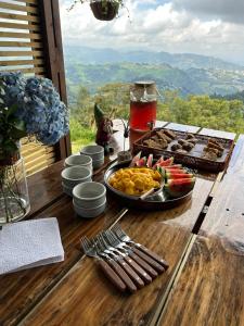 einen Tisch mit einem Tablett mit Essen auf einem Tisch in der Unterkunft Owl's Watch Nature Retreat in Manizales