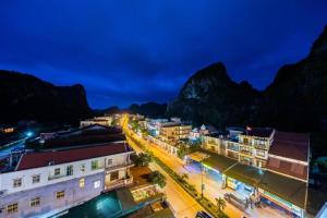 a city at night with mountains in the background at Phong Nha Jasmine Hostel & Roof Top Bar in Quang Binh