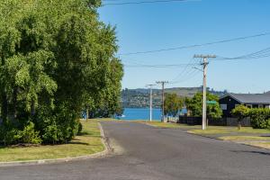an empty road with a lake in the background at Close to the Lake in Taupo