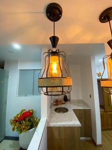 cocina con fregadero y lámpara en Huallata Hotel Boutique, en Huaraz