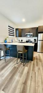 uma cozinha com um balcão e duas cadeiras em Comfortable entire townhouse in downtown Edmonton. em Edmonton