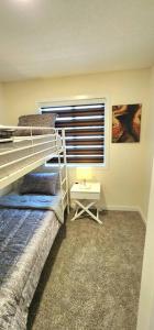 ein Schlafzimmer mit einem Etagenbett und einem Nachttisch in der Unterkunft Comfortable entire townhouse in downtown Edmonton. in Edmonton