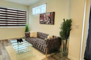 a living room with a brown couch and a glass table at Comfortable entire townhouse in downtown Edmonton. in Edmonton