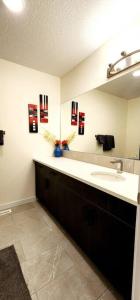 a bathroom with a sink and a mirror at Comfortable entire townhouse in downtown Edmonton. in Edmonton
