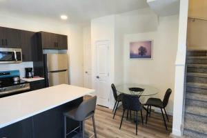 a kitchen with a table and chairs and a counter at Comfortable entire townhouse in downtown Edmonton. in Edmonton