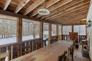 a dining room with a large wooden table and windows at The Stock Farm in Chestertown