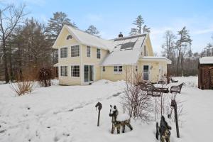 a house with two dogs standing in the snow at The Stock Farm in Chestertown