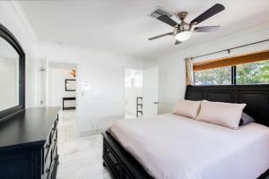 a bedroom with a bed and a ceiling fan at Marble House in Lauderdale Harbours in Fort Lauderdale