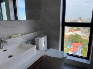 a bathroom with a sink and a toilet and a window at The Vincent Condo in Phnom Penh