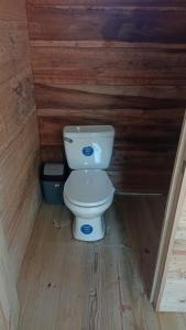 a bathroom with a toilet in a wooden wall at Casa Manatí in Lívingston