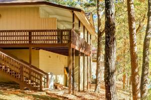 une maison avec une terrasse couverte et des escaliers dans les bois dans l'établissement Lakeside Bliss, à Hot Springs Village