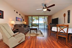 a living room with a ceiling fan and a couch at Valley Isle 302 in Kahana
