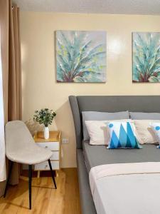 a bedroom with a bed and a table and a chair at Seawind Condominium 2 Bedroom Near Samal and Airport in Davao City