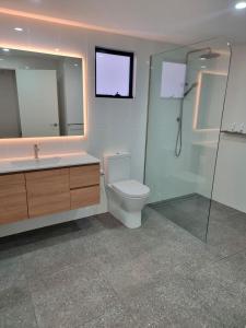 a bathroom with a toilet and a sink and a shower at Yungaburra Whitehouse in Yungaburra +28 photos