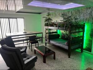 Zimmer mit 2 Etagenbetten und grüner Beleuchtung in der Unterkunft Apartaestudio con Baño y Cocina Apto para Mascotas in Pereira