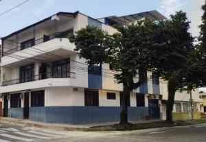ein weißes und blaues Gebäude mit zwei Bäumen davor in der Unterkunft Apartaestudio con Baño y Cocina Apto para Mascotas in Pereira