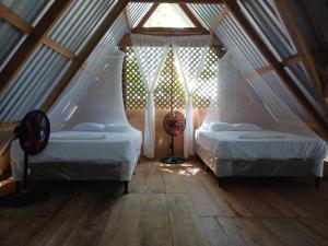 two beds in a attic room with a window at Casa Manatí in Lívingston