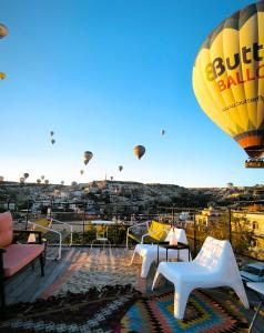 a bunch of hot air balloons flying in the sky at Karadut Cave Hotel in Göreme